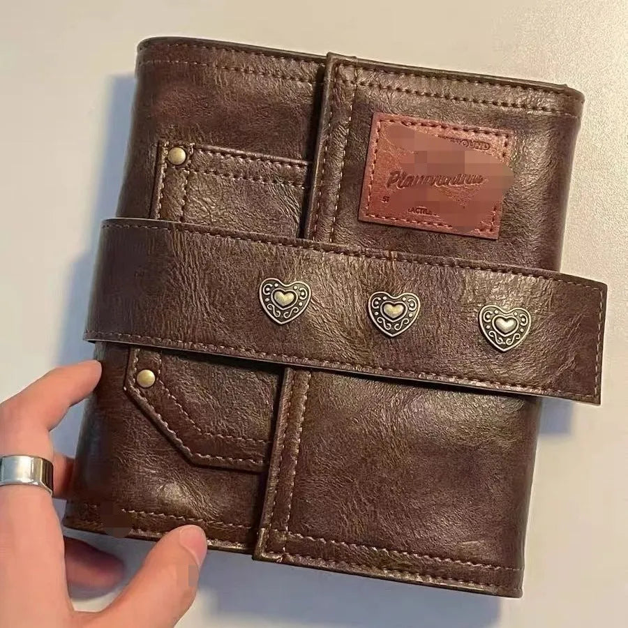 Brown A7 loose-leaf notebook with PU cover and retro buckle design, shown open.