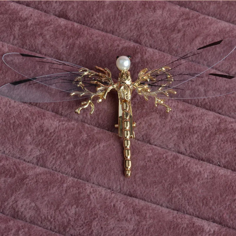 Golden dragonfly-shaped alloy hair clip with electroplated finish and a clip fastening.