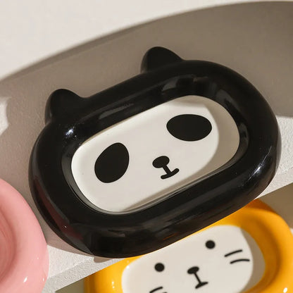 Four ceramic animal-themed pet bowls with frog, panda, pig, and fortune cat designs and silicone non-slip bases
