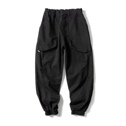 Solid colour cotton casual pants with large pockets and a tapered, ankle-tied silhouette.