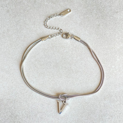 Elegant letter charm bracelets for women in gold and silver tones, featuring a delicate snake chain design and personalised letter charms.