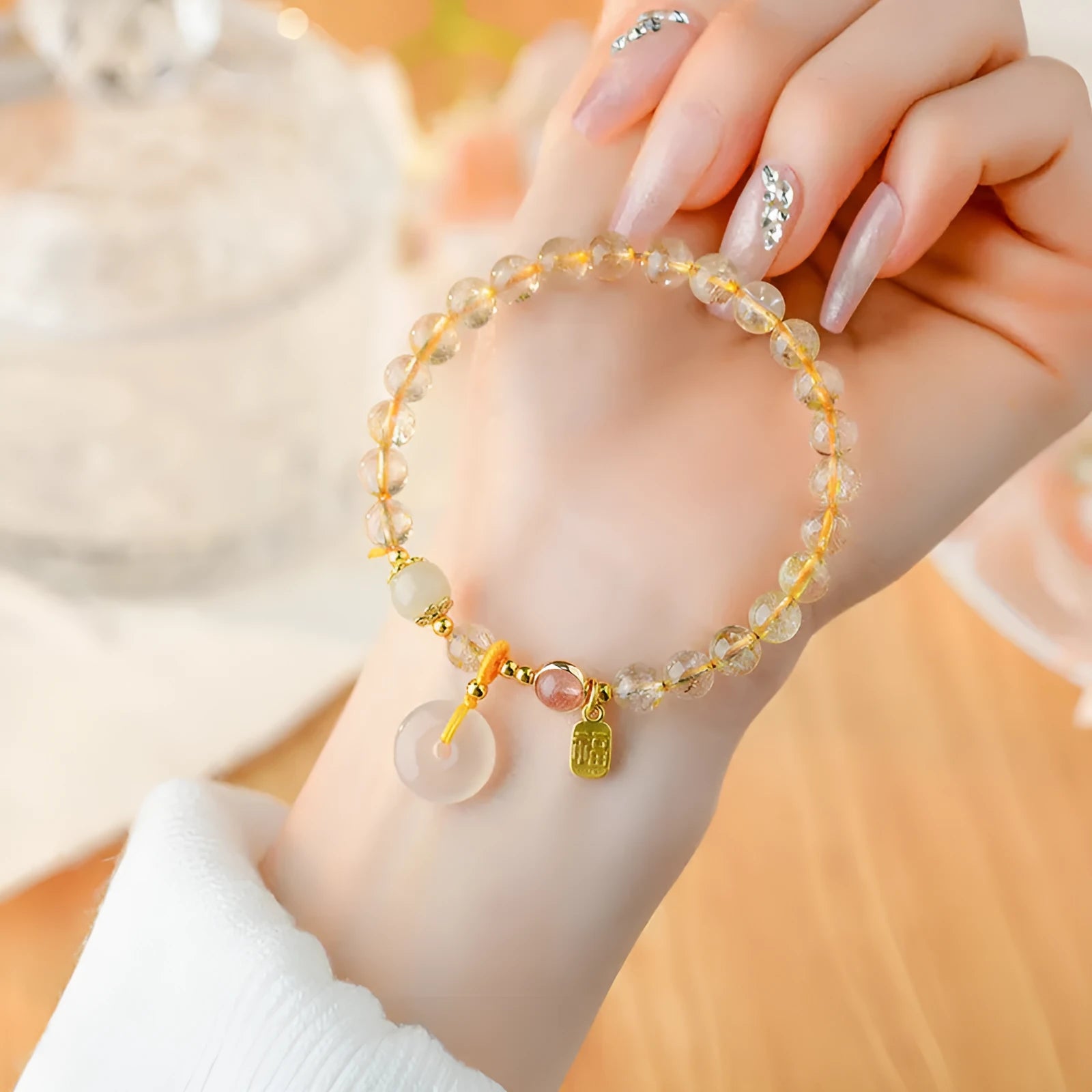 Gold rutilated quartz crystal bracelet with geometric peace buckle pendant and safety clasp