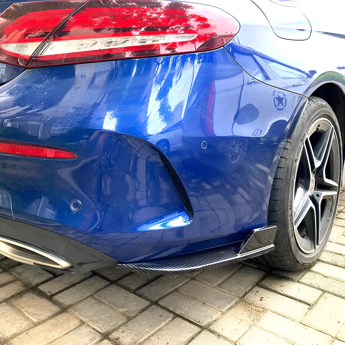 Car rear corner protectors in PP plastic, shown in piano black and carbon fibre pattern finishes