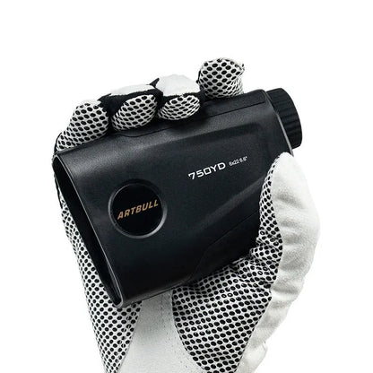 Black golf laser rangefinder with LCD display showing yardage, placed on a green golf towel.