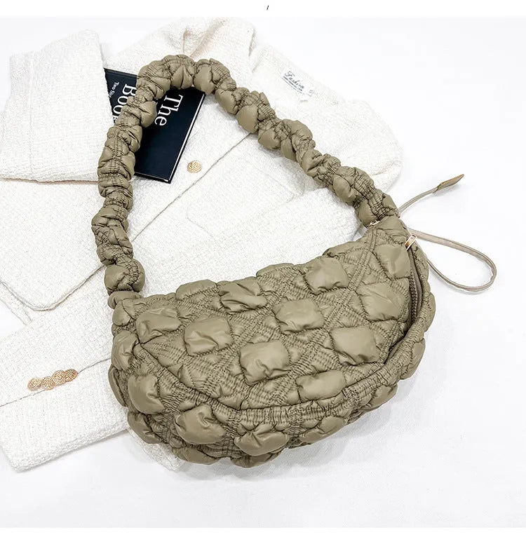 Women's light grey nylon underarm messenger bag with adjustable long strap, shown worn crossbody.