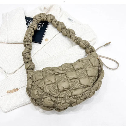 Women's light grey nylon underarm messenger bag with adjustable long strap, shown worn crossbody.