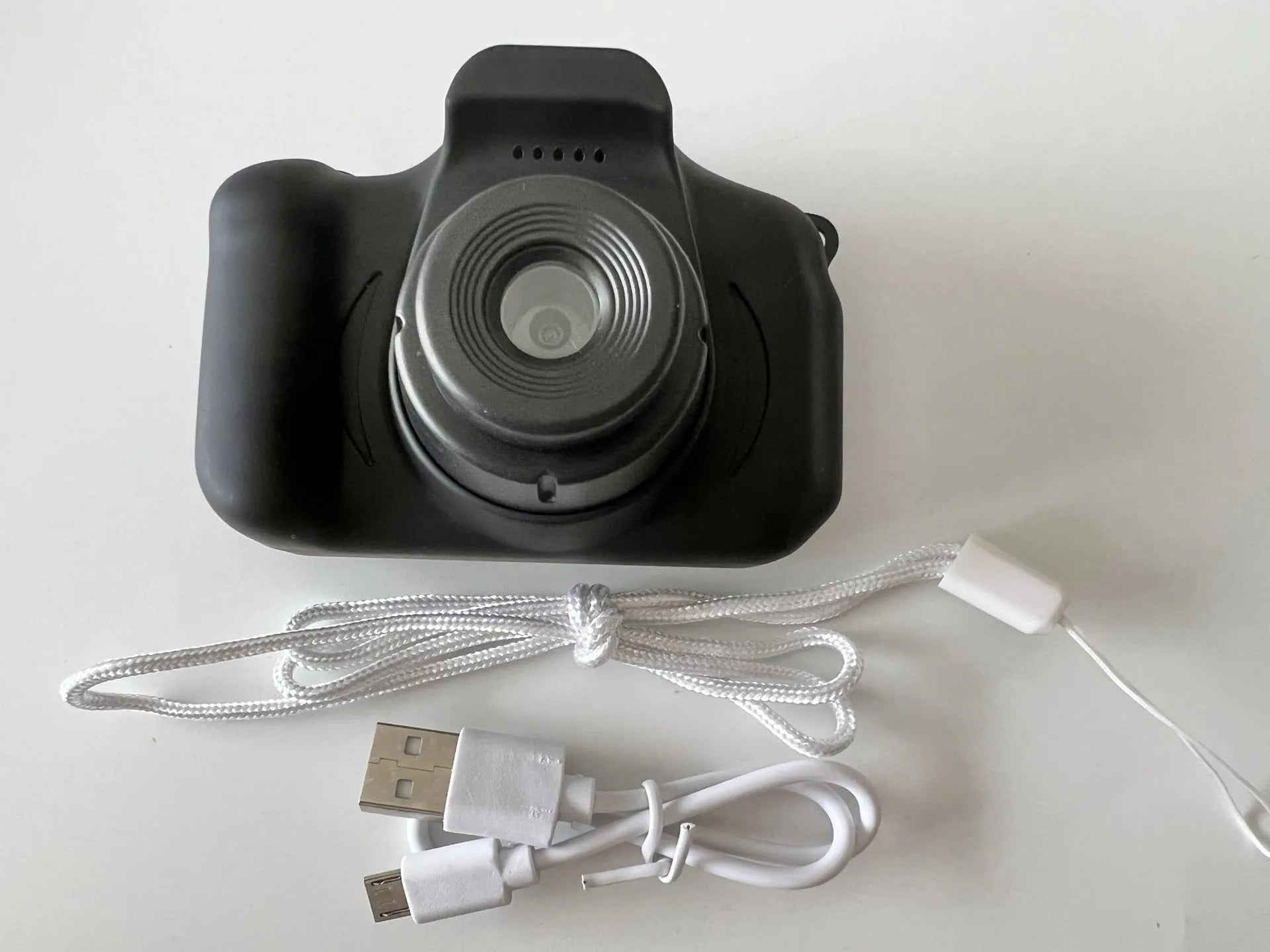 X2 HD mini digital camera for kids in silicone case with lanyard, shown capturing photo on 2-inch screen.