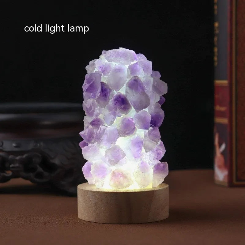 Mini USB night light glowing inside a natural amethyst crystal vug geode on a dark surface.