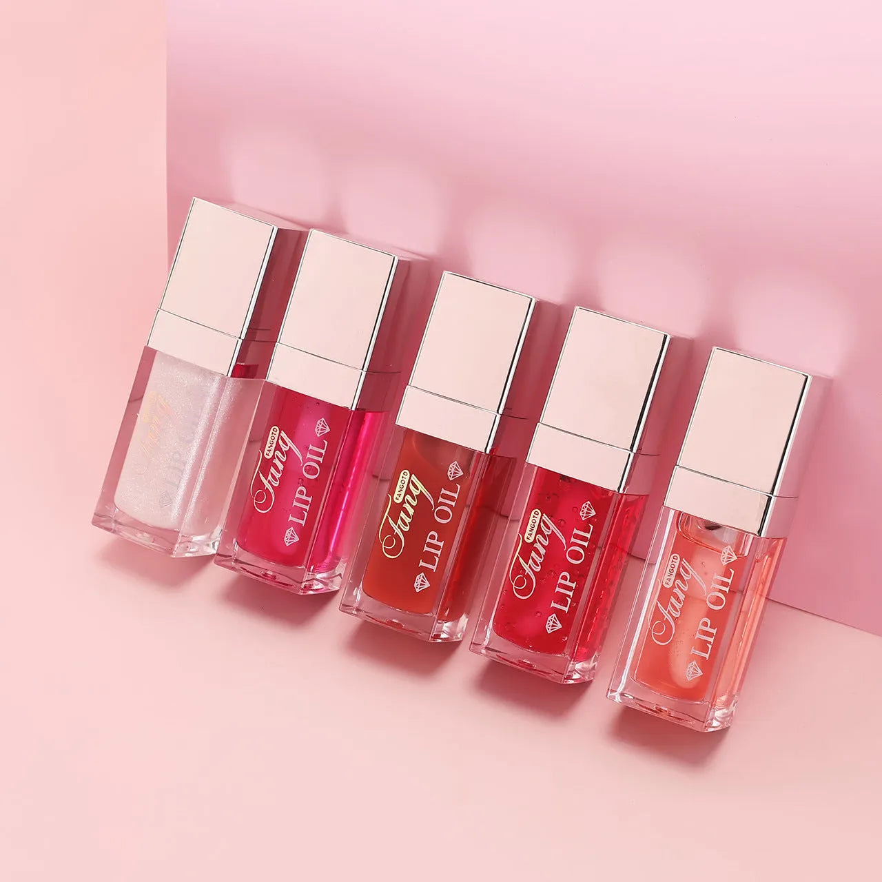 Set of five bright lip gloss tubes with lip essence oil applicators in shades Style001, 006, 007, 012, and 015.