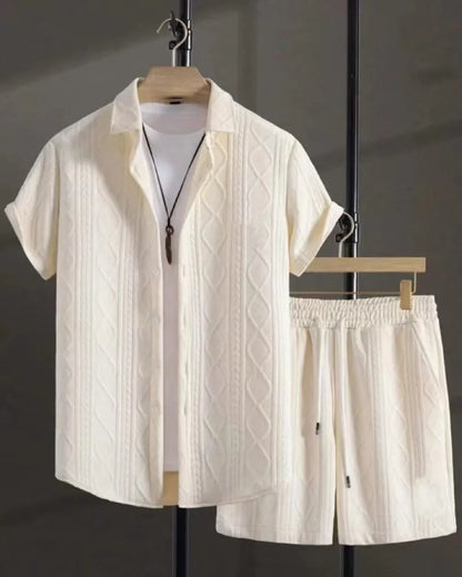 Man wearing a black and white jacquard short sleeve shirt and matching shorts suit set.