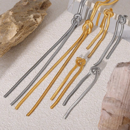 Gold electroplated titanium steel necklace with snake chain and knotted tassel pendant, shown with matching earrings.