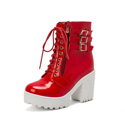 Women's black chunky heel ankle boots with round toe and front lace-up on a wooden floor.