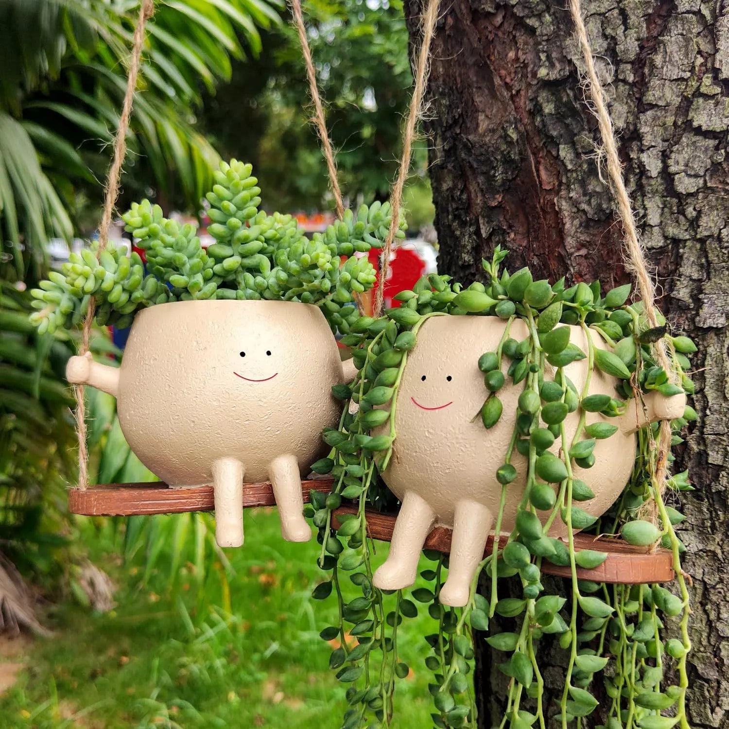 Swing face hanging flower pot with child's smiling design, made of durable resin