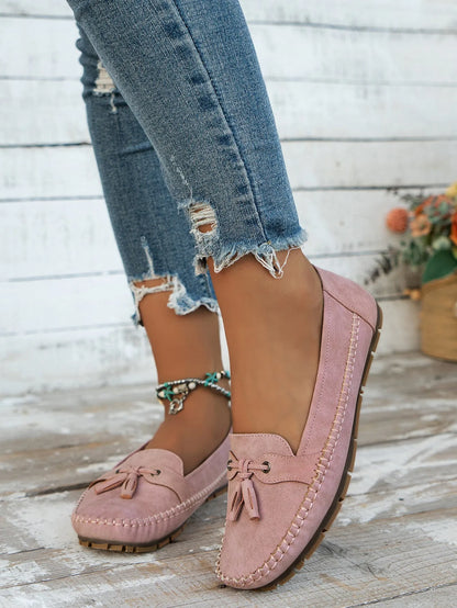 Women's solid-colour suede flat shoes with a bow on the front, shown in apricot colour.