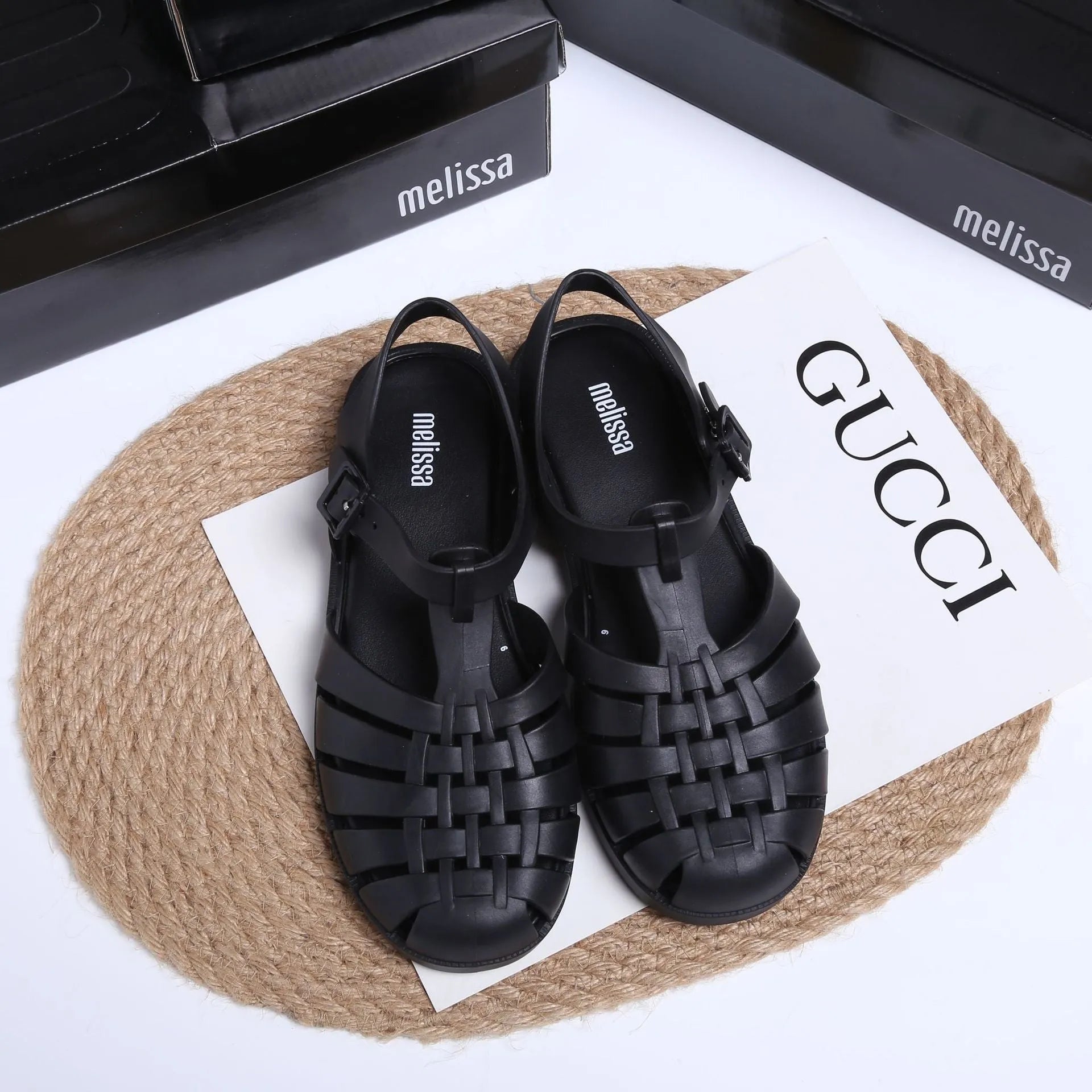 Matte black Roman sandals with vintage weave pattern, buckle fastening, and low-top PVC construction