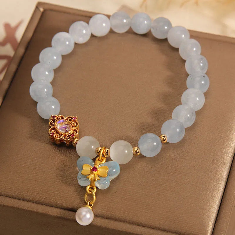 Women's crystal bracelet with a blue aquamarine butterfly pendant and rhinestone details.