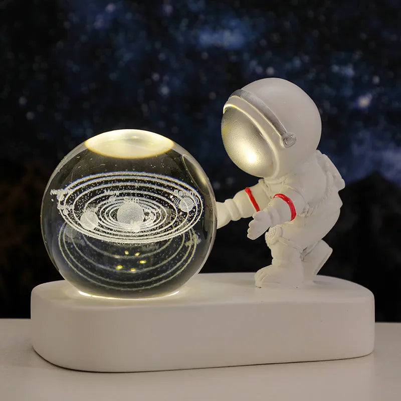 Glowing astronaut crystal ball night light with 6cm diameter and USB cable on wooden surface