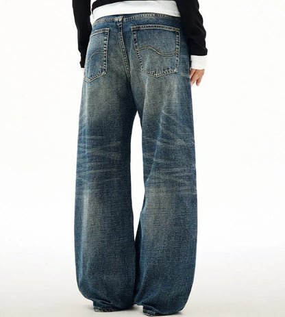 Men's wide leg mid waist jeans in dark blue denim with straight loose cut and distressed cat beard detail