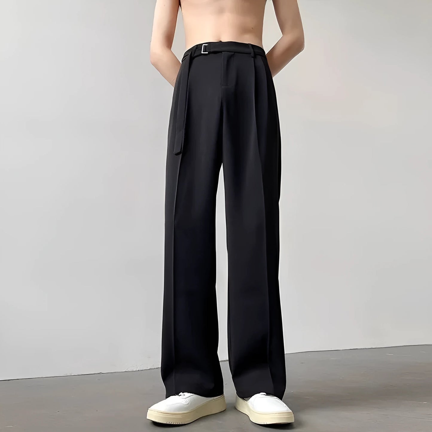 A pair of black straight leg wide fit women's trousers with a loose, casual silhouette on a hanger.