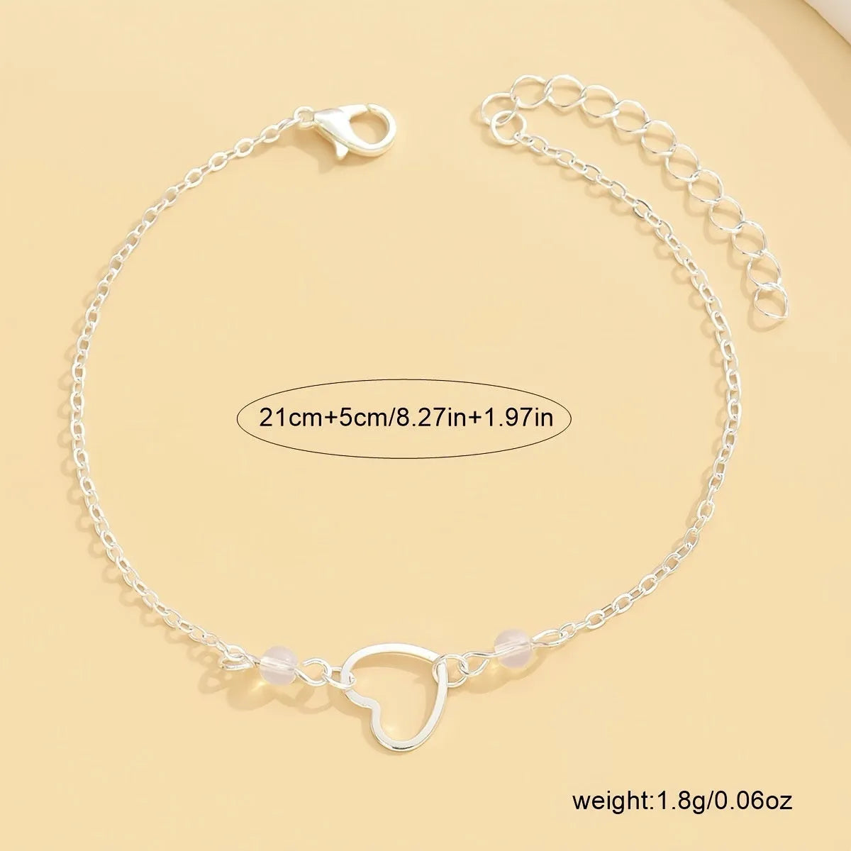 Gold and silver adjustable women's ankle bracelets with a small heart pendant on a chain.