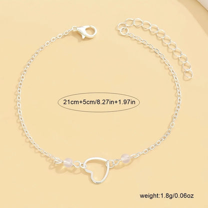 Gold and silver adjustable women's ankle bracelets with a small heart pendant on a chain.
