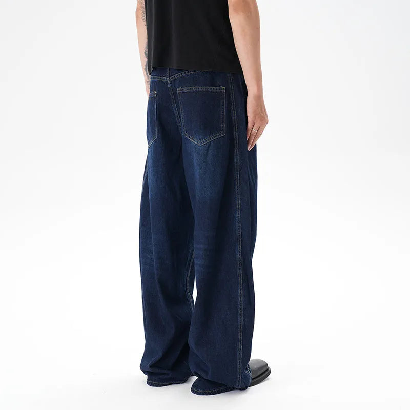 Dark blue distressed wide leg Machete jeans laid flat, showing washed denim texture.