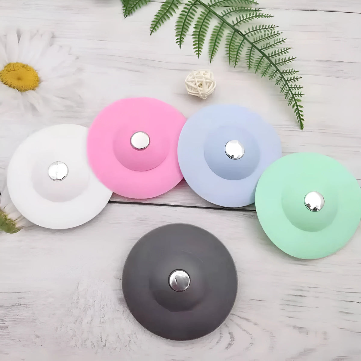UFO-style silicone press sink drain cover in white, pink, gray, blue, and green