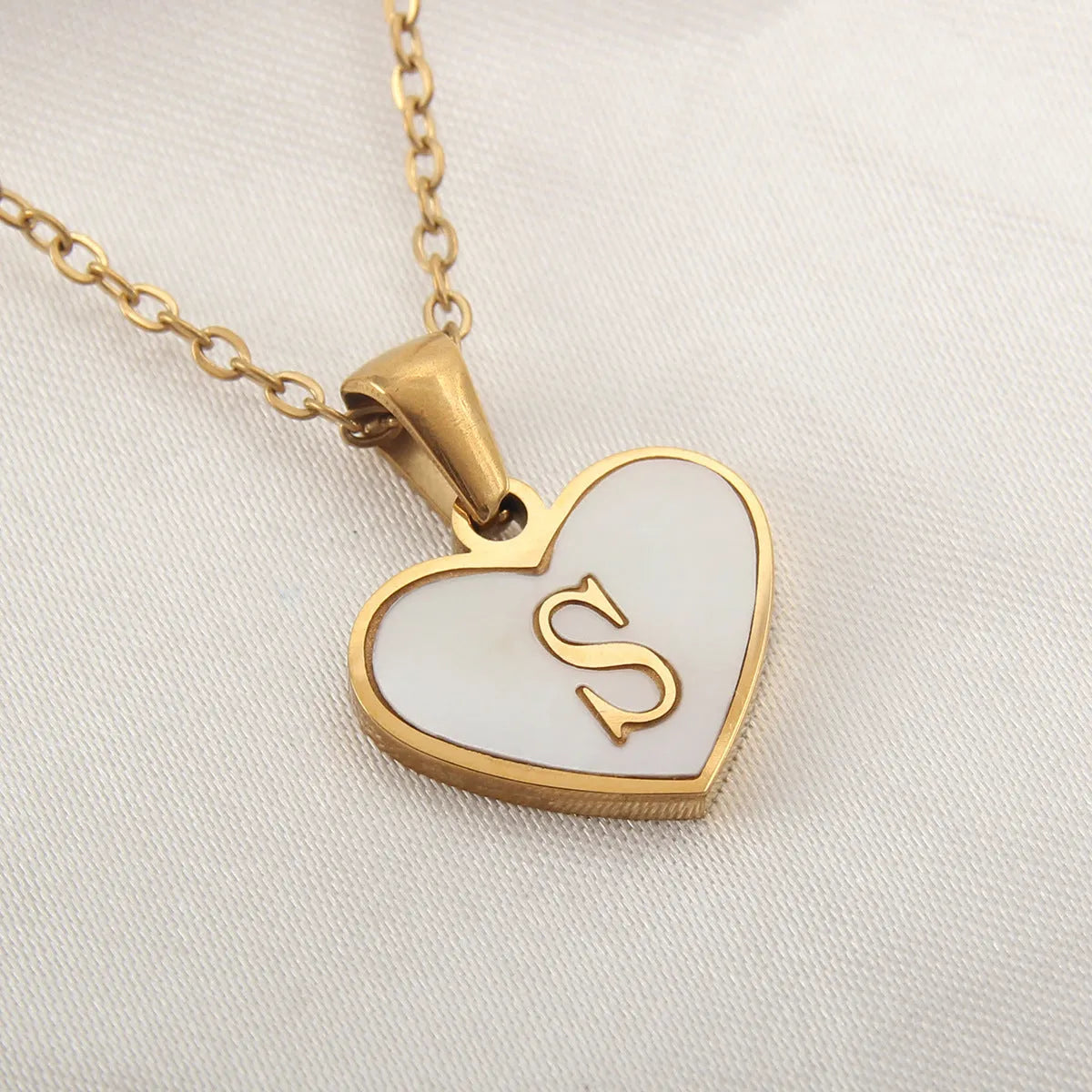 Gold-plated heart necklace with white shell pendant showing letter personalisation option