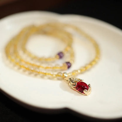 Natural gold rutilated quartz bracelet with Chinese style three circles and hanging chopsticks design.