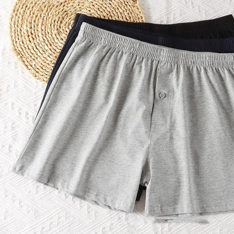 Men's light grey cotton boxer shorts with a loose fit and high waist on a plain background.