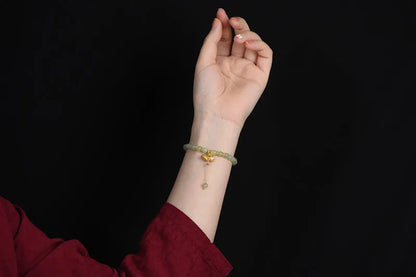 Natural Hetian jade bracelet with 6mm beads, engraved fu character, and constellation design on a simple string.