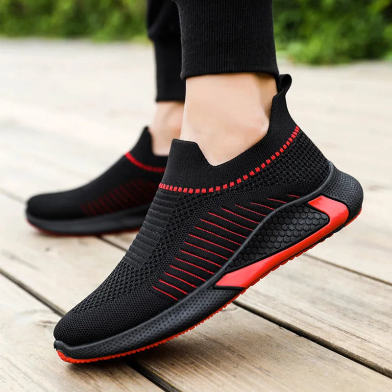 Men's black and white striped slip-on sneakers with lace-up front and mesh upper.