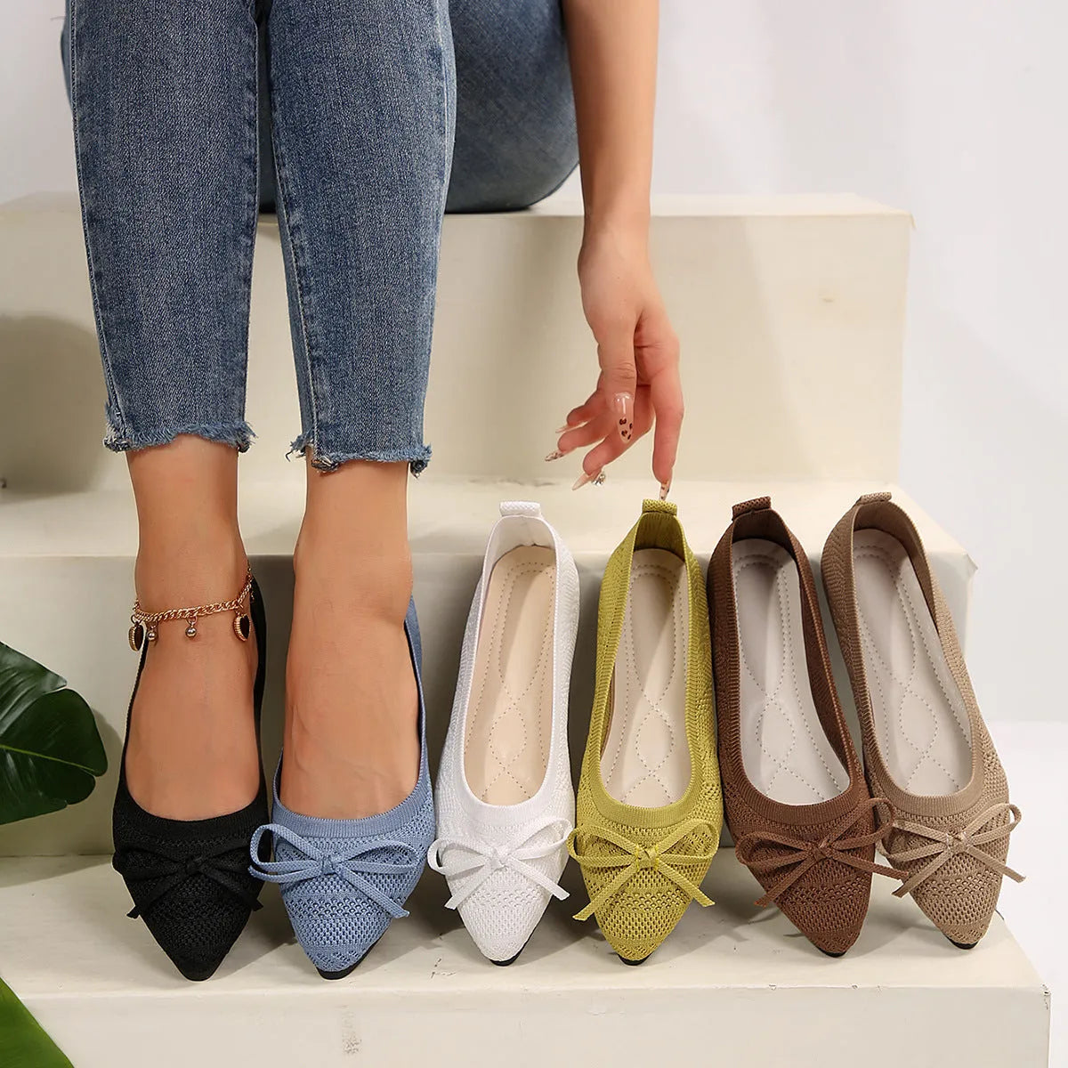 Women's blue knitted loafer flat shoes with a pointed toe and decorative bow detail on the front.