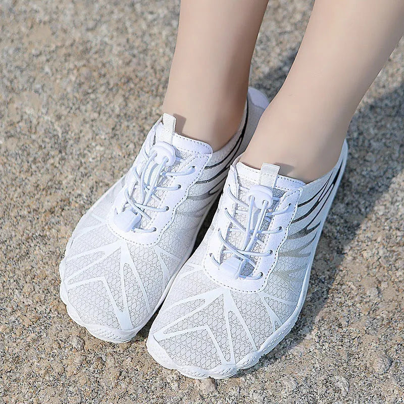 Men's and women's low-top breathable sports running shoes with a natural rubber sole on a hard ground surface.