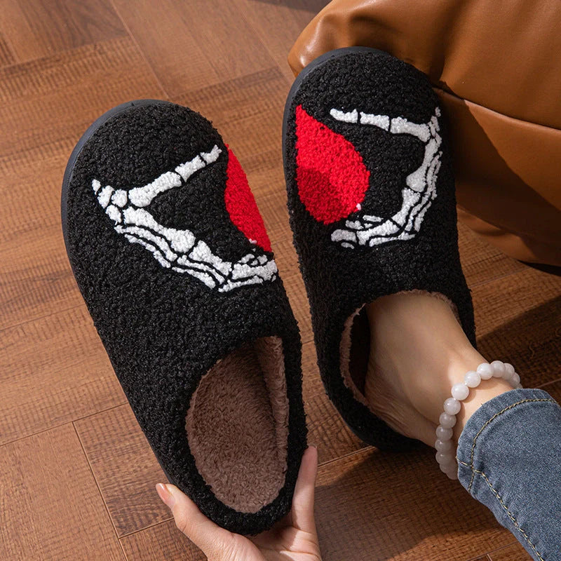 Halloween-themed skull-hand slippers in black and white, featuring non-slip soles for indoor comfort.