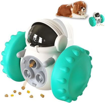 A black, robot-shaped treat dispenser toy for dogs and cats on a wooden floor, showing its size and rolling design.