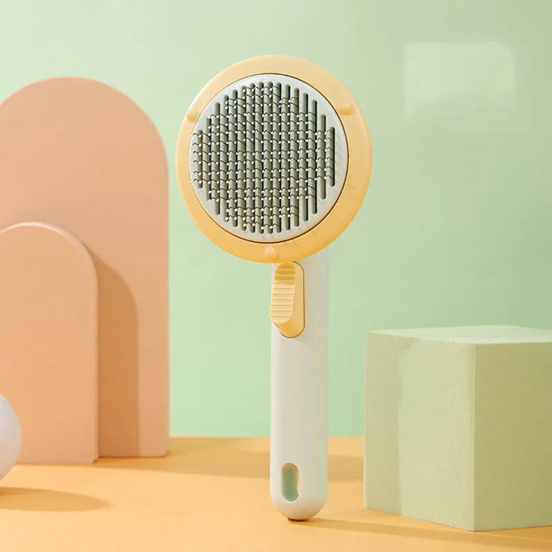Hand-held pumpkin-coloured pet brush with stainless steel needles for grooming cats and dogs