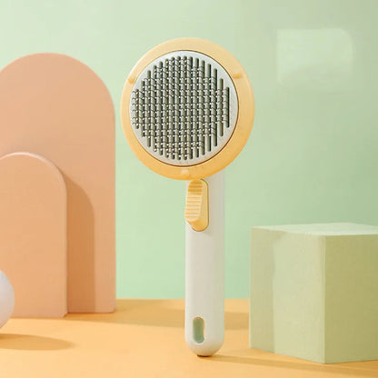 Hand-held pumpkin-coloured pet brush with stainless steel needles for grooming cats and dogs