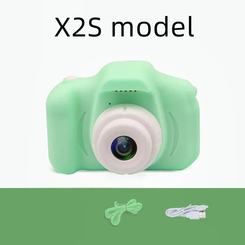 X2 HD mini digital camera for kids in silicone case with lanyard, shown capturing photo on 2-inch screen.