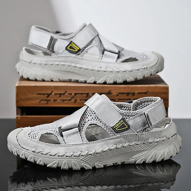 Men's gray casual sandals with mesh panels, leather upper, elastic strap, and rubber sole.