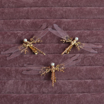 Golden dragonfly-shaped alloy hair clip with electroplated finish and a clip fastening.