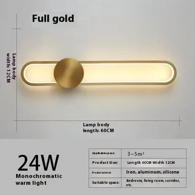 Modern black wall lamp with a long adjustable arm and round shade, mounted beside a bed.