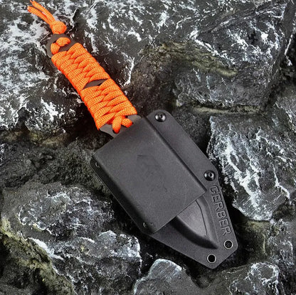 Straight-blade survival knife with a binding rope handle next to its black ABS plastic sheath.