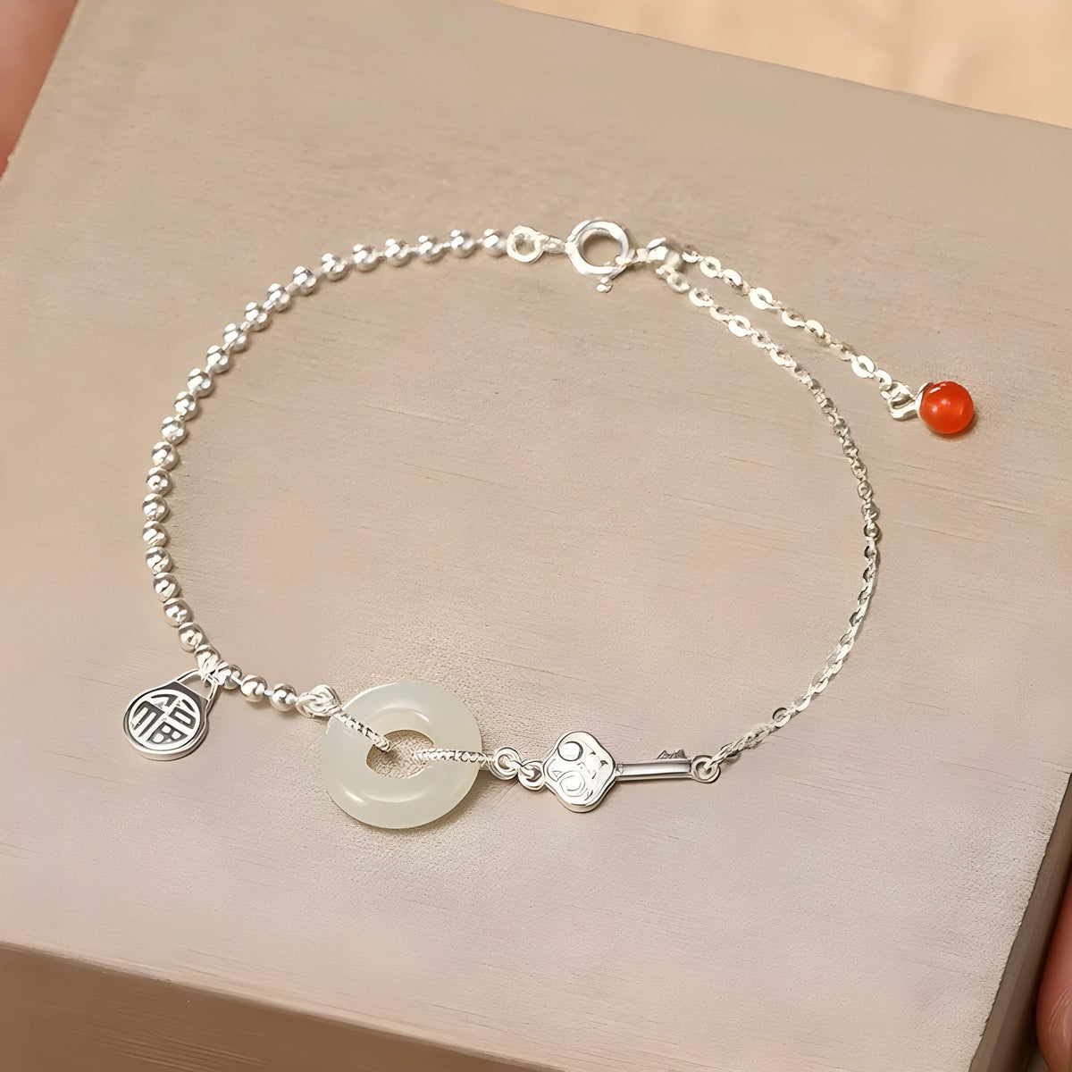 Silver women's bracelet with Hetian jade stones and a geometric peace buckle charm.
