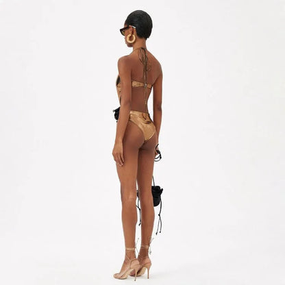 Gold handmade halter one-piece swimsuit with hollow out floral pattern on a mannequin.