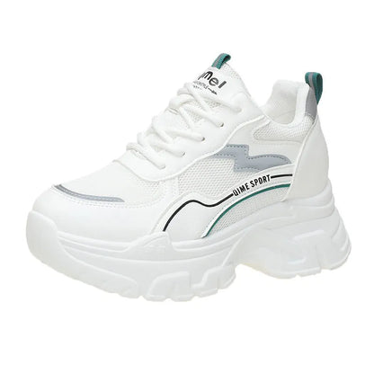 White women's dad sports trainers with cross straps and a lace-up front on a rubber sole.