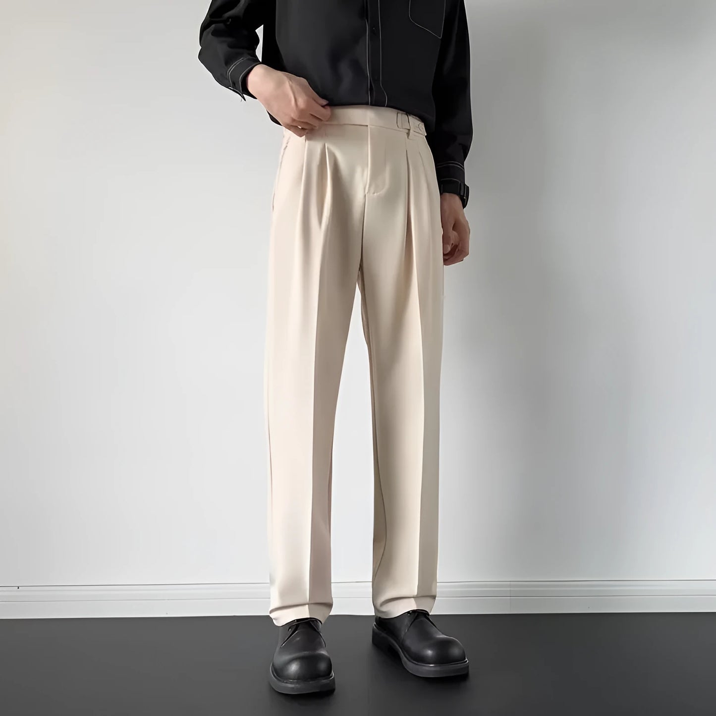 Men's apricot and black straight-leg loose-fit trousers laid flat, showing waistband and full leg.