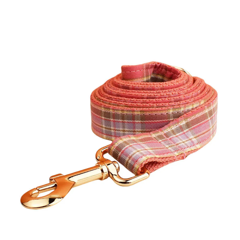 Red plaid cloth dog collar and leash set with matching bow on a white background