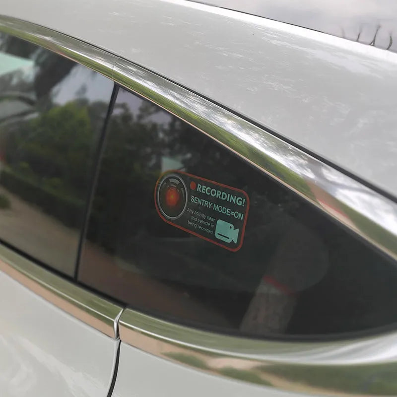 Pair of rectangular 11x5cm Tesla Sentry Mode warning stickers with English text on clear electrostatic backing.