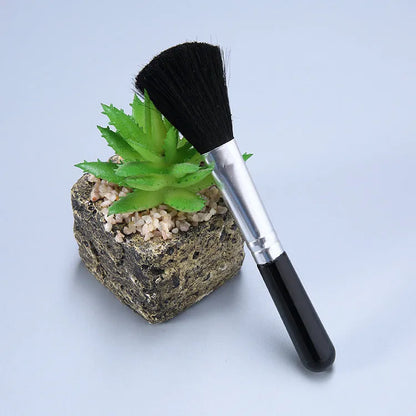 Diamond painting repair tool set with metal scraper pen, bottle of adhesive liquid, soft brush, and bamboo stick on a craft table